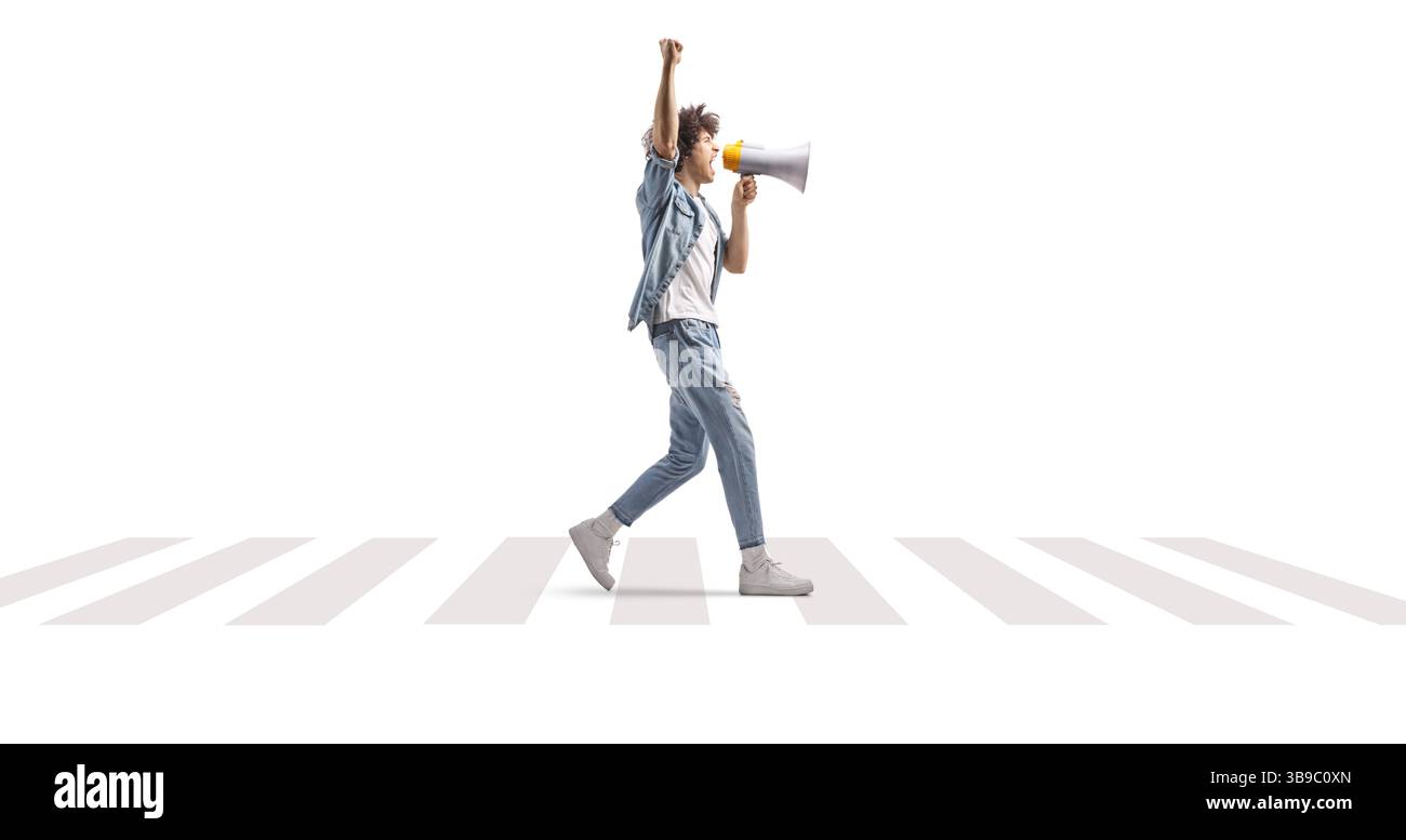 Junger Mann, der an einer Zebraüberquerung mit einem Megaphon läuft und isoliert auf weißem Hintergrund schreien kann Stockfoto