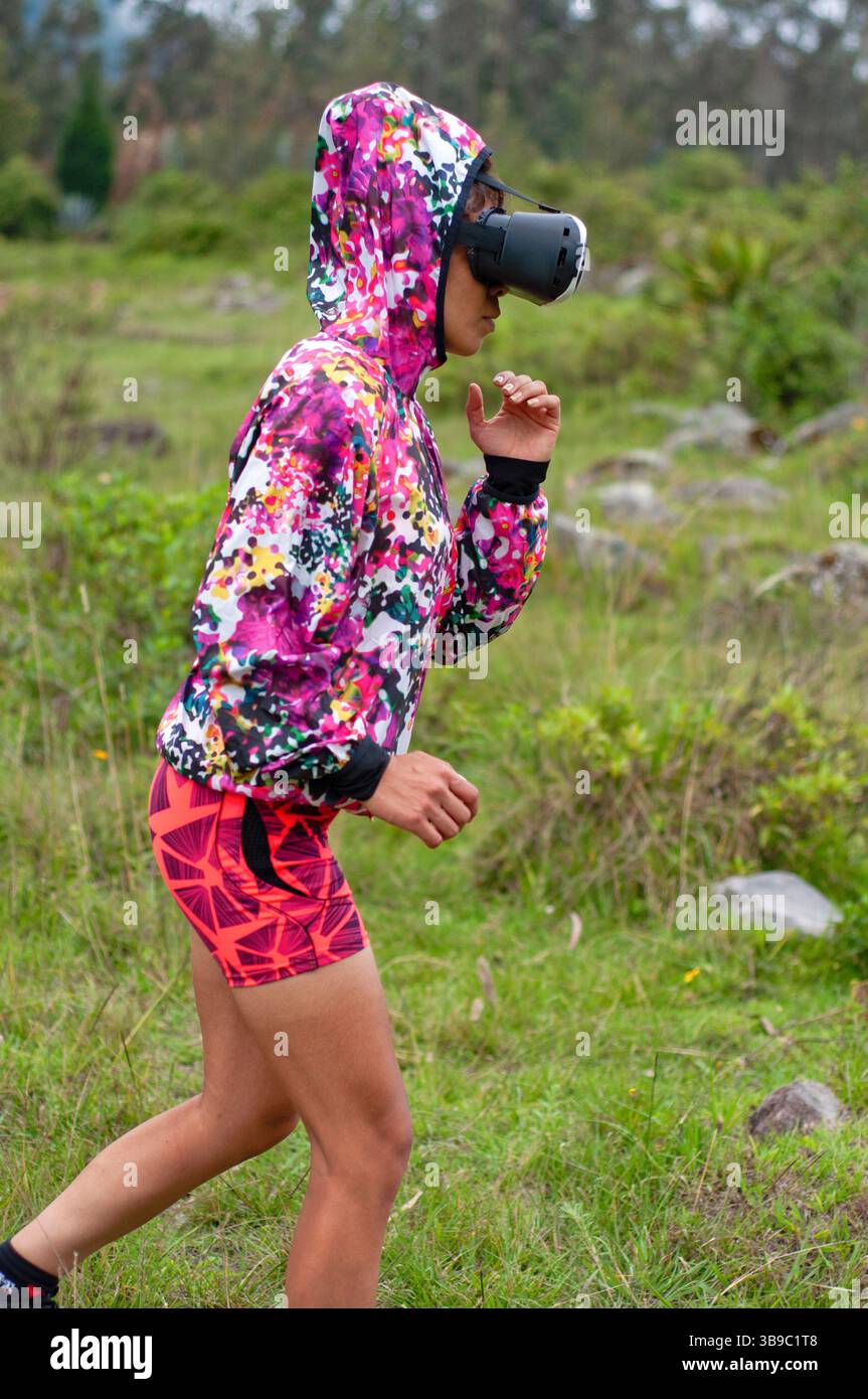 Eine Frau joggt im Freien in lebendiger Sportswear, trägt eine Virtual-Reality-Schutzbrille und genießt einen aktiven Lebensstil. Stockfoto