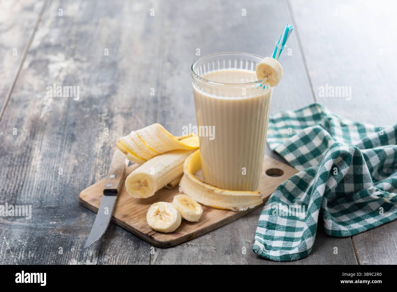 Frischer und gesunder Bananen-Smoothie im Glas auf Holztisch Stockfoto