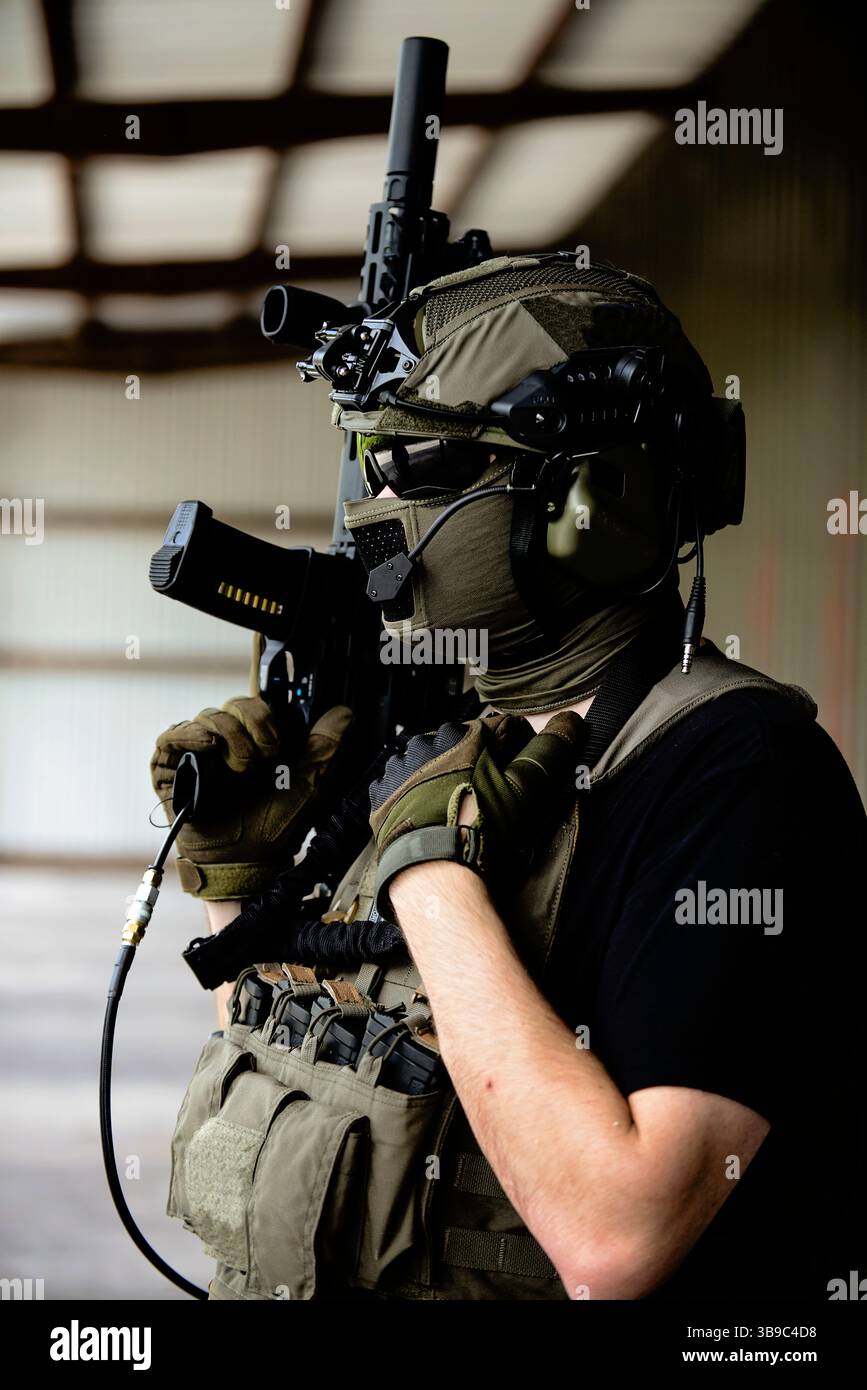 Airsoft-Spieler mit erhöhter M4-Pistole Stockfoto