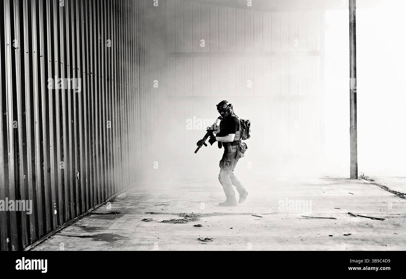 S&W-Foto eines männlichen Airsoft-Players, der durch Rauch läuft Stockfoto