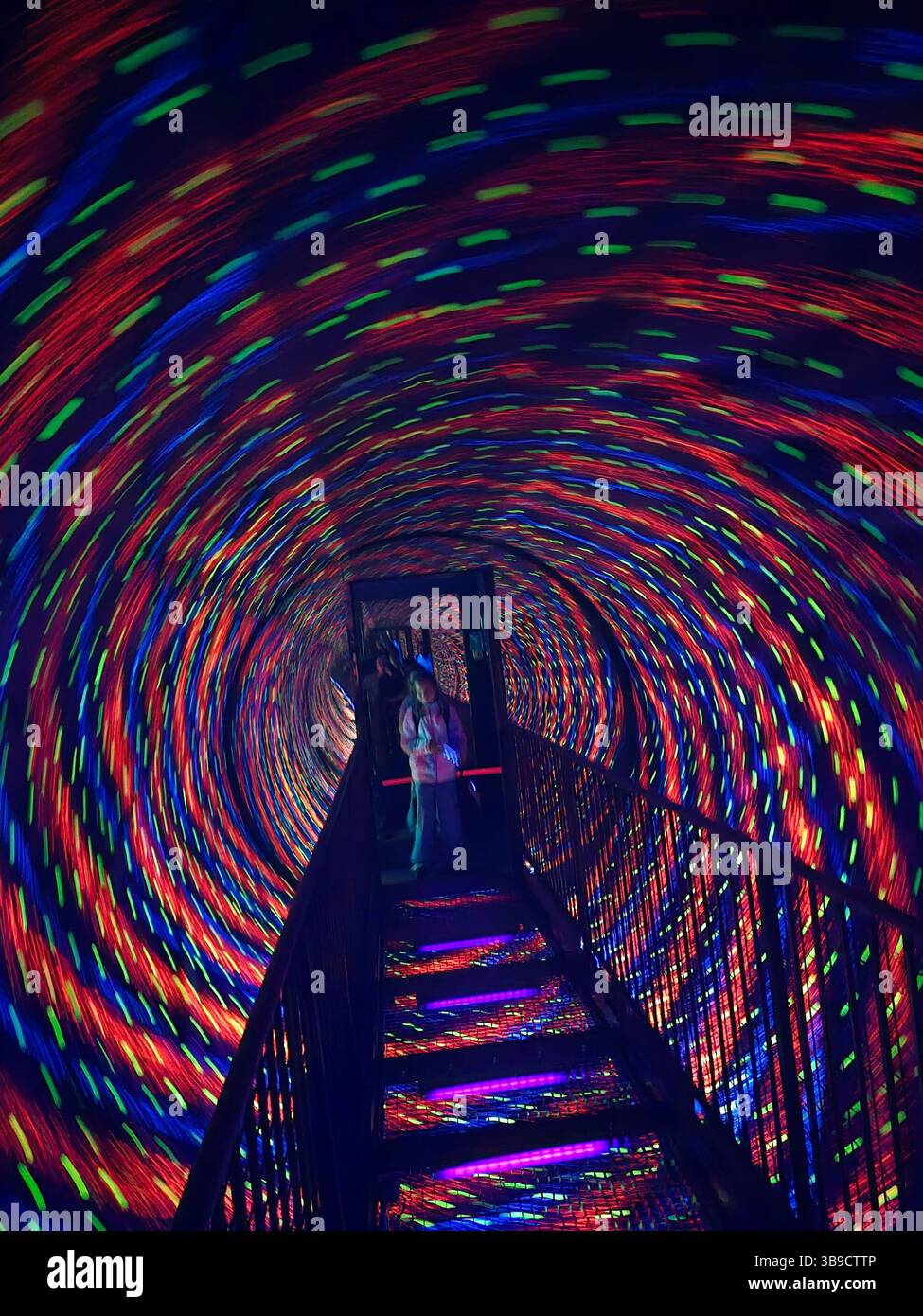 Tauchen Sie ein in einen faszinierenden Wirbel aus wirbelnden Farben, wo lebendige Lichter einen hypnotischen Tunneleffekt erzeugen, der ein immersives, psychedelisches Erlebnis ist. - Smartphone-aufgenommenes Stockfoto