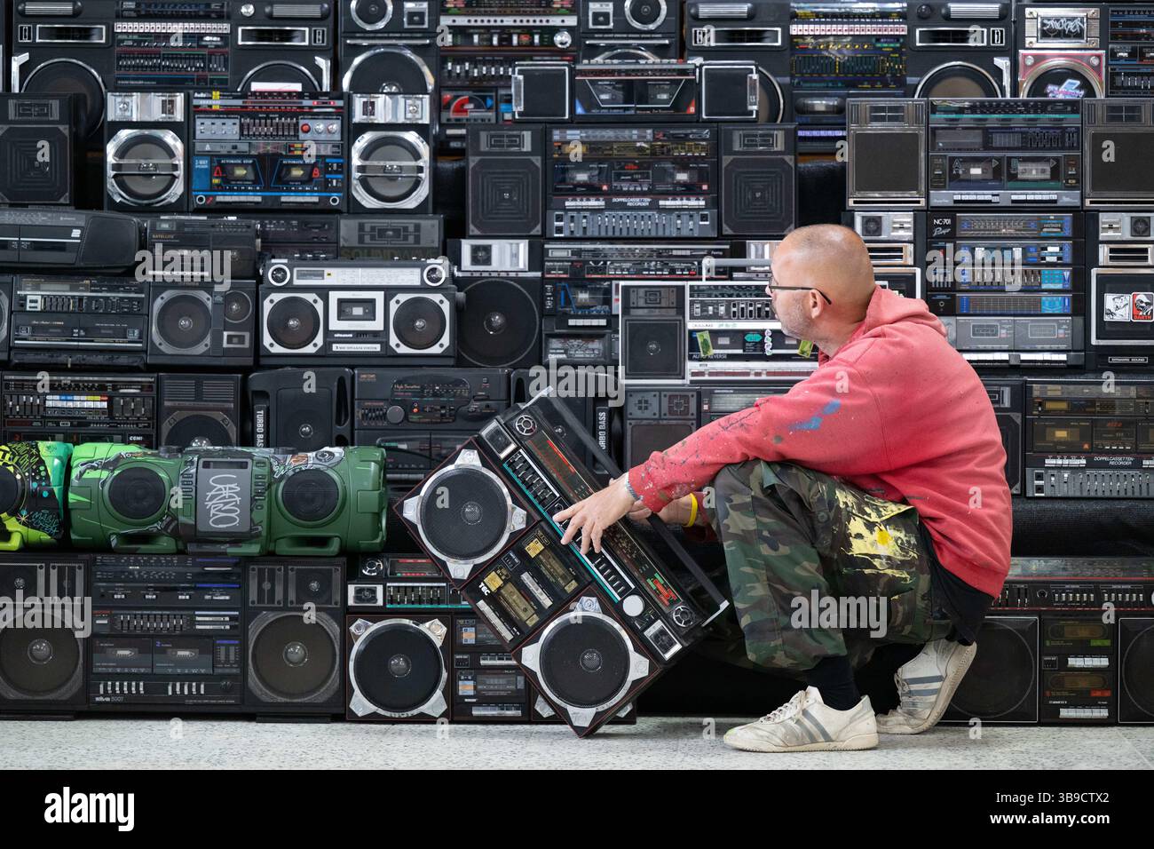 Dresden, Deutschland. Mai 2025. Sebastian Girbig kontrolliert seine Sammlung von rund 60 tragbaren Musiksystemen, umgangssprachlich auch Boomboxen genannt, in der ehemaligen Robotron-Kantine. Die Sammlung ist Teil des erstmals stattfindenden Hip-Hop-Festivals ALL4/1, das bis zum 11. Mai 2025 die facettenreiche Hip-Hop-Kultur in Dresden präsentieren soll. Quelle: Sebastian Kahnert/dpa/Alamy Live News Stockfoto