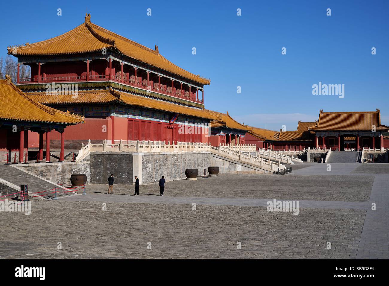 Ein Weitwinkelblick auf die traditionelle chinesische kaiserliche Architektur in der Verbotenen Stadt Peking, aufgenommen an einem klaren Frühlingnachmittag mit ein paar Besuchern Stockfoto