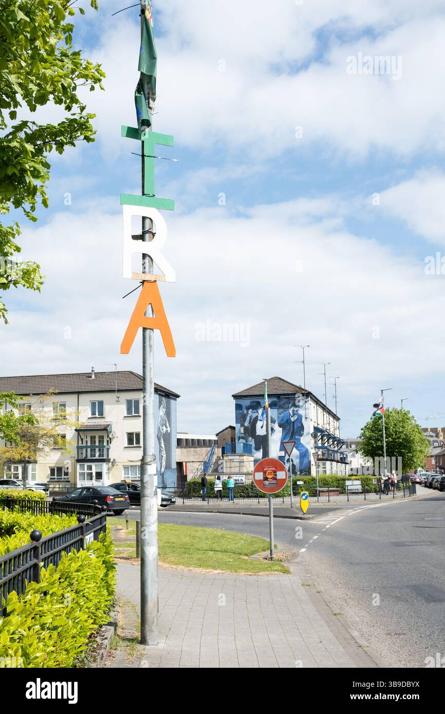 Derry / Londonderry, Nordirland - 7. Mai 2025: IRA-Schild in grün weiß und orange Buchstaben auf der Laternenlaterne mit Blick auf das Runner-Wandbild in Bogside Stockfoto