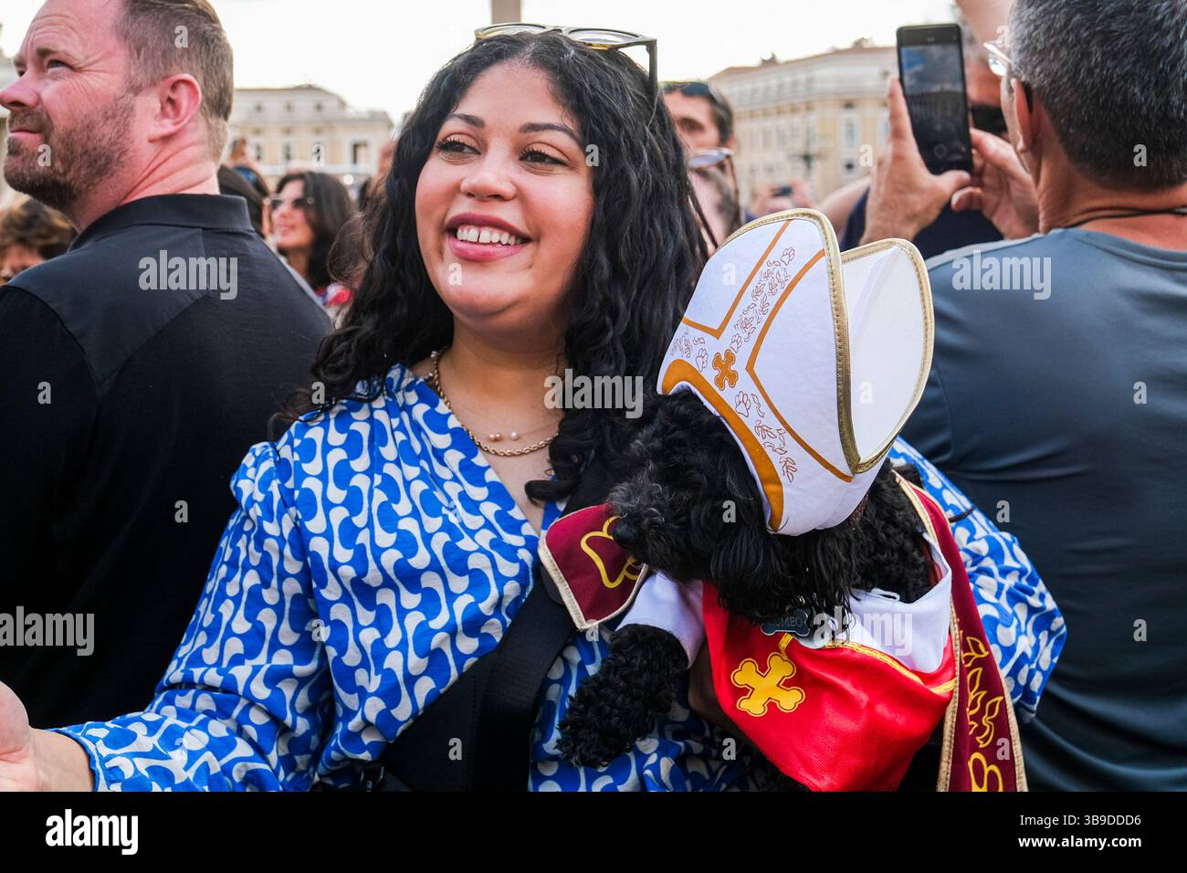 Eine Frau posiert mit ihrem Hund Romeo, gekleidet als Papst, am zweiten Tag des Konklaves im Vatikan am 8. Mai 2025 auf dem Petersplatz Stockfoto
