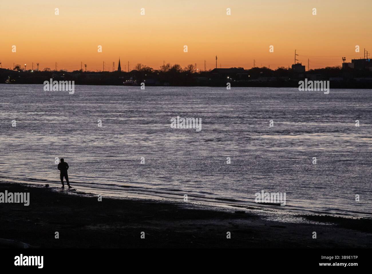 Gretna, Louisiana - Ein Mann steht am Ufer des Mississippi River gegenüber von New Orleans. Stockfoto