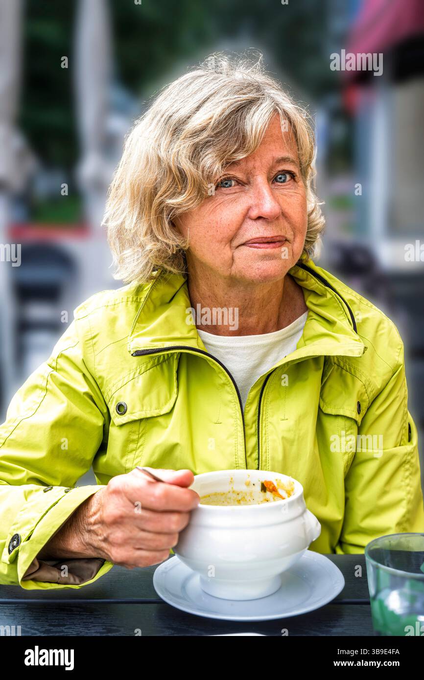 Eine schwedische blonde Frau, die eine Suppe genießt Stockfoto