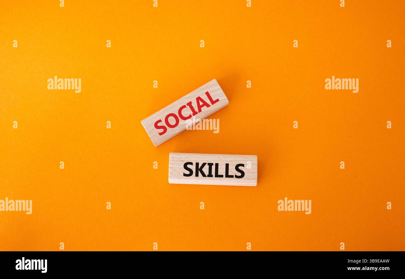 Symbol für soziale Kompetenzen. Holzblöcke mit Worten soziale Fähigkeiten schöner oranger Hintergrund. Konzept der unternehmerischen und sozialen Kompetenzen. Kopierbereich. Stockfoto