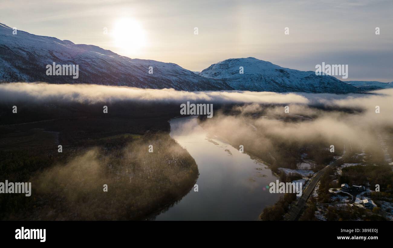 Wunderschöne Flußkulisse in Nordnorwegen, bedeckt mit Wolken und Nebel, umgeben von Bergen. Winding River wurde auf eine Drohne geschossen. Stockfoto