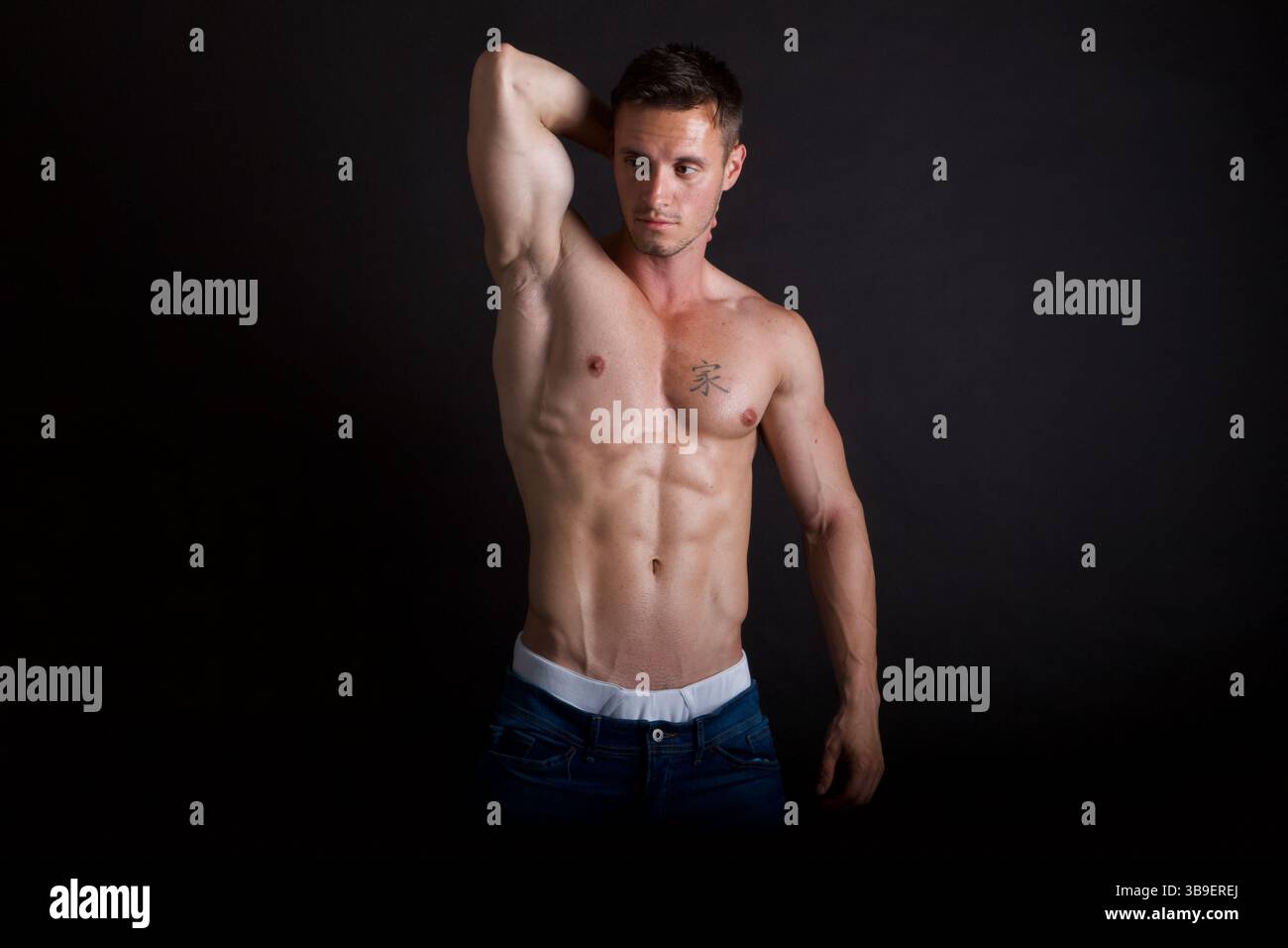 Männliches Modell mit einer Hand hinter dem Kopf Stockfoto
