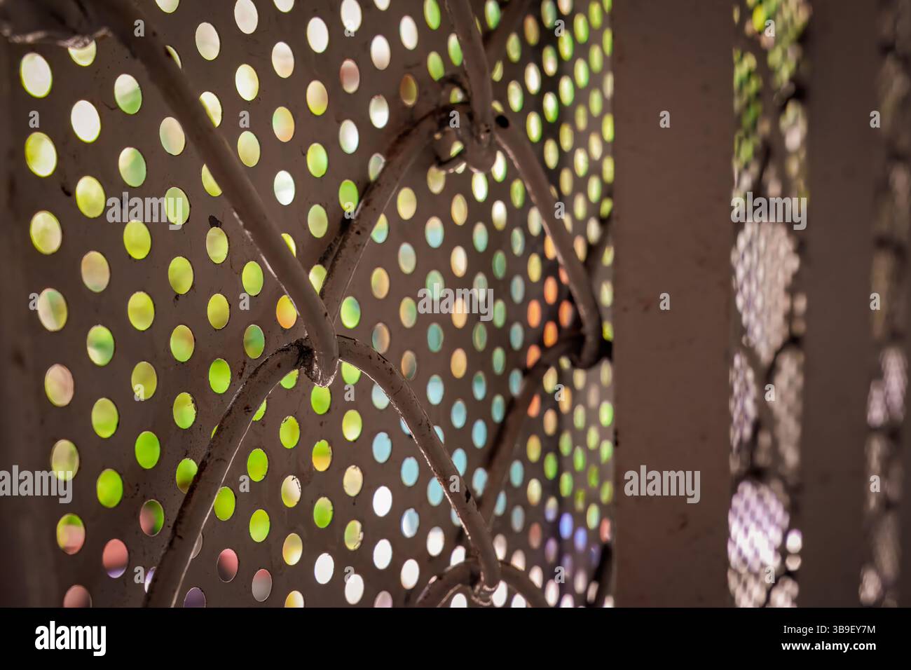 Perforiertes Metallblech mit buntem, unscharfem Hintergrund Stockfoto