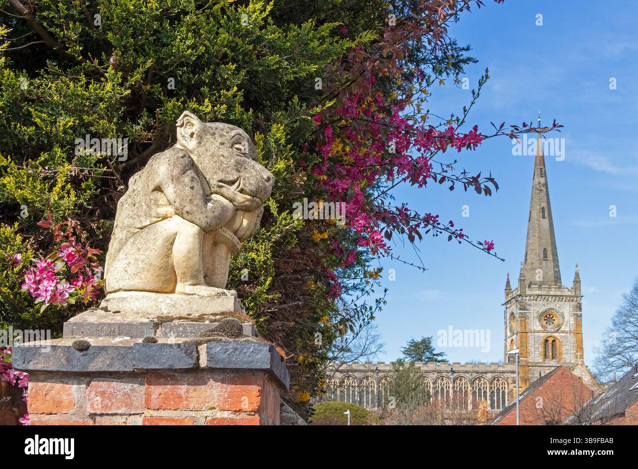 Mythische Kreatur, die unter dem blühenden Busch sitzt und die Holy Trinity Church, Stratford-upon-Avon, Warwickshire, England, Großbritannien ansieht Stockfoto