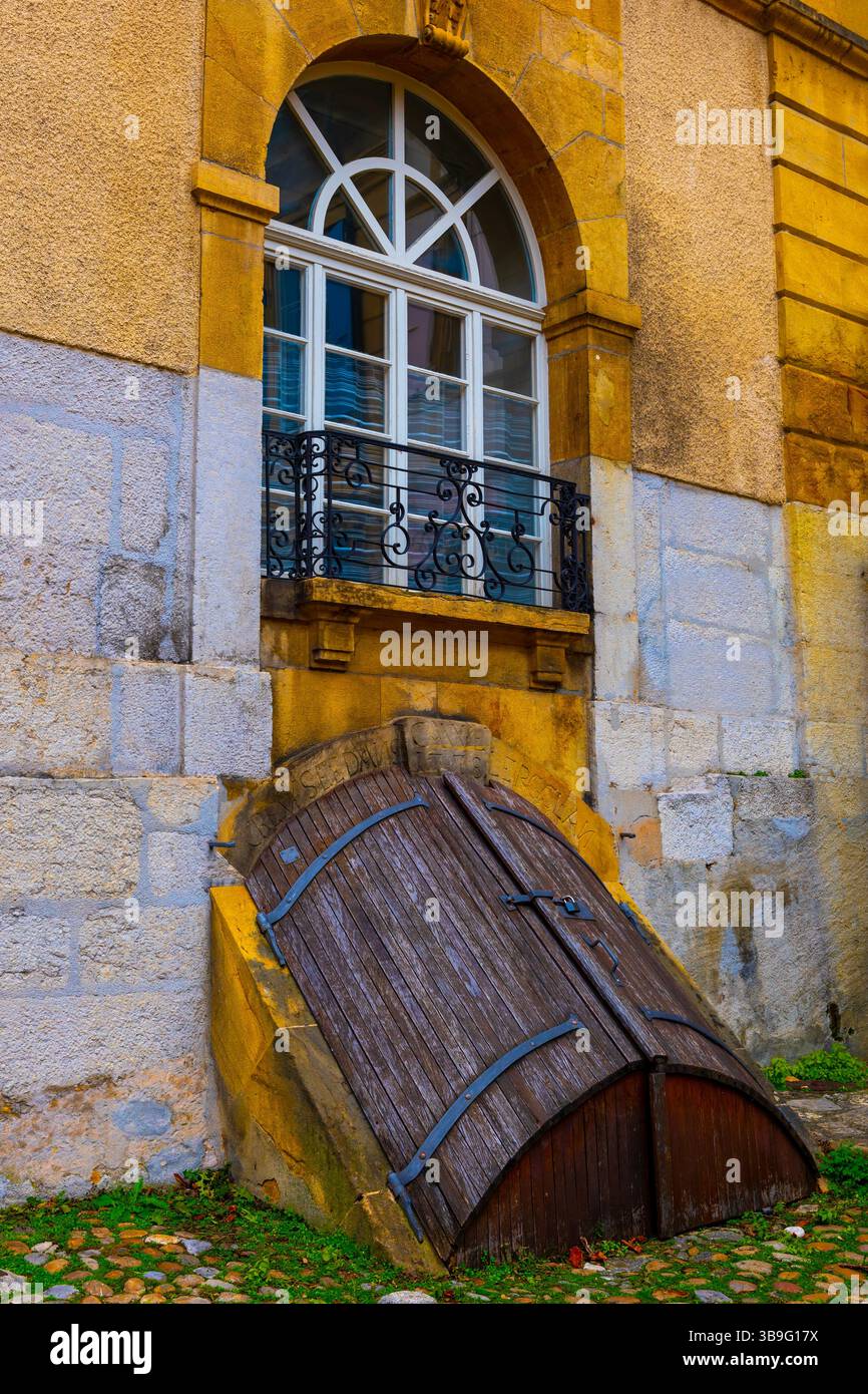 Kopfsteinpflasterstraße in der Altstadt mit Haus und Fenster mit Kellertür in der Stadt Neuchatel, Kanton Neuchatel, Schweiz. Stockfoto