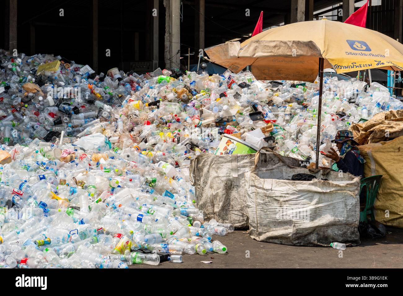 9. Mai 2025, Bangkok, Thailand: Ein Arbeiter, der in einem lokalen Lager vor einem Haufen Plastikflaschen und Artikel nach Plastiktypen sortiert. Abfallsortierer sind ein wesentlicher Bestandteil des Recyclingsystems. Sortieren, Wiegen und Vorbereiten von Materialien für den Wiederverkauf an größere Recyclingunternehmen oder -Fabriken, was zur Kreislaufwirtschaft beiträgt. Trotz ihrer wesentlichen Rolle bei der Entsorgung von Kunststoffabfällen und ihrer begrenzten formellen Infrastruktur fehlt es diesen Frontarbeitern oft an Arbeitsschutz, sozialer Anerkennung und wirtschaftlicher Stabilität. (Kreditbild: © Nathalie Jamois/SOPA Images Via Stockfoto