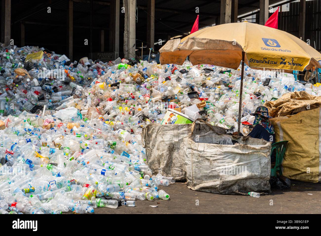 9. Mai 2025, Bangkok, Thailand: Eine Ansicht eines Müllsortierers mit einem Haufen Plastikflaschen und anderen Plastikartikeln, die darauf warten, in einem lokalen Lager in verschiedene Beutel getrennt zu werden. Abfallsortierer sind ein wesentlicher Bestandteil des Recyclingsystems. Sortieren, Wiegen und Vorbereiten von Materialien für den Wiederverkauf an größere Recyclingunternehmen oder -Fabriken, was zur Kreislaufwirtschaft beiträgt. Trotz ihrer wesentlichen Rolle bei der Entsorgung von Kunststoffabfällen und ihrer begrenzten formellen Infrastruktur fehlt es diesen Frontarbeitern oft an Arbeitsschutz, sozialer Anerkennung und wirtschaftlicher Stabilität. (Foto: © Nathalie Jamo Stockfoto