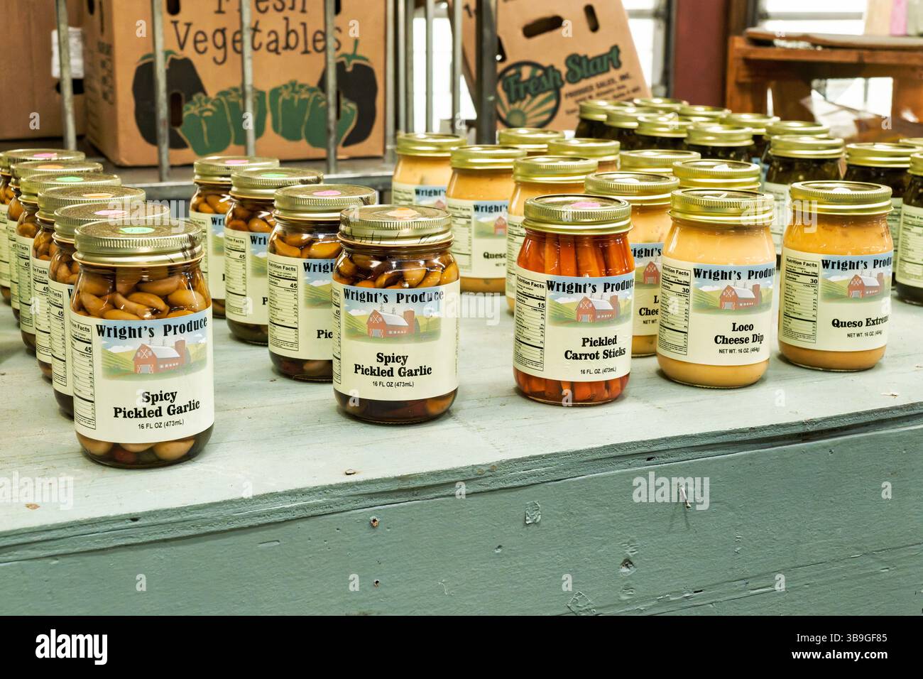Gläser mit eingelegten Kräutern, Gemüse und Käse an einem Verkaufsstand auf einem lokalen Bauernmarkt in Montgomery Alabama. Stockfoto