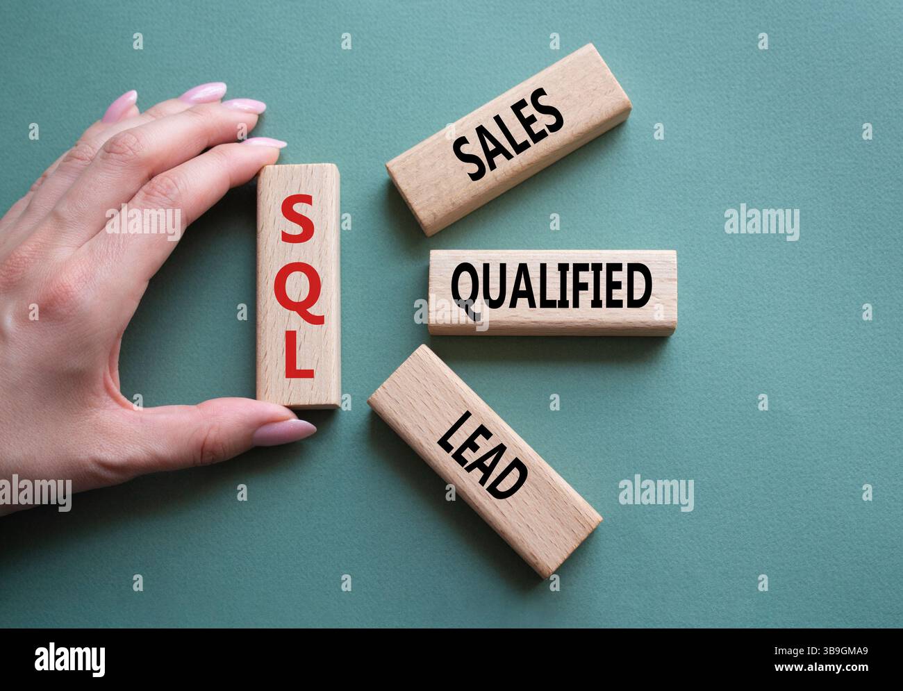 SQL - qualifizierter Lead für Vertrieb. Holzwürfel mit SQL-Wörtern. Geschäftsmann Hand. Wunderschöner graugrüner Hintergrund. Business- und SQL-Konzept. Kopierbereich. Stockfoto