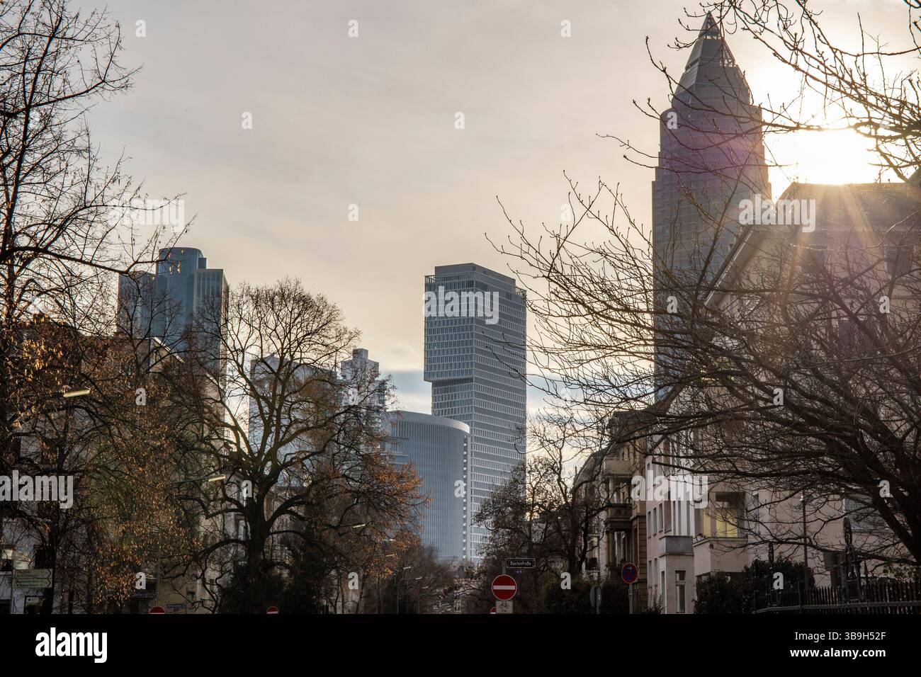 Eine große Stadt am Abend bei Sonnenuntergang. Moderne Gebäude in einer Skyline. Moderne Architektur hinter historischen Gebäuden. Straßenfoto der Metropole Frankfurt am Main, Deutschland Stockfoto