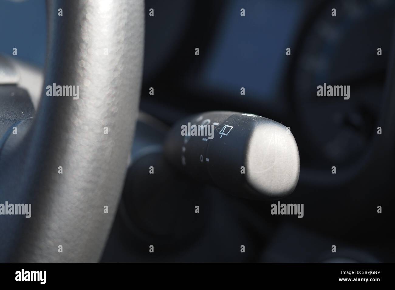 Details zu den Lenkradbedienelementen eines Fahrzeugs in sanfter Beleuchtung Stockfoto