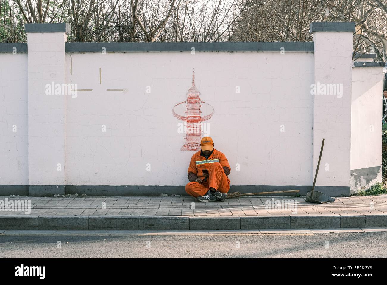 Sanitärangestellte ruht unter einem Wandgemälde des Porzellanturms von Nanjing (Bao'en-Tempel), China Stockfoto
