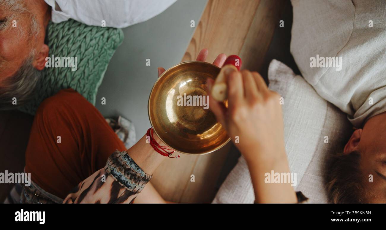Tibetische Schüssel, Heilung und Hände einer Person im Studio für Wellness-Retreat, Entspannung und Meditation. Chakra-Balance, Ruhe- und Klangtherapie mit oben Stockfoto