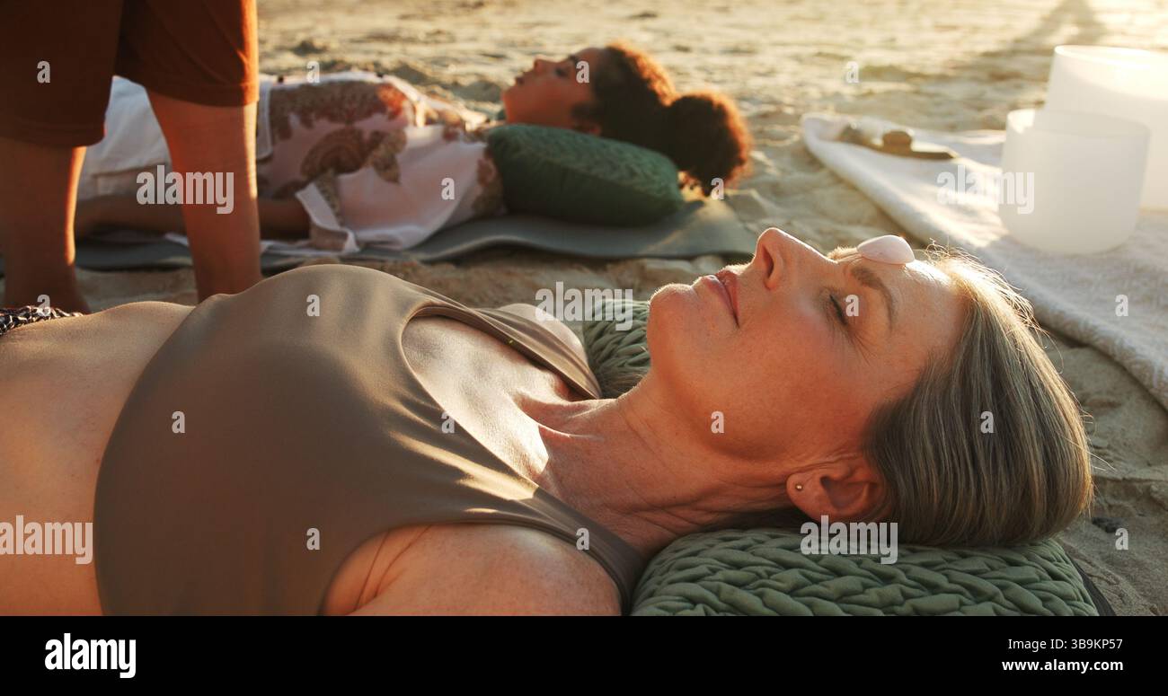 Frauen, Kristall und Energie am Strand mit Chakra Gleichgewicht, Therapie und Heilung mit Erholung im Urlaub. Menschen, Stein und ganzheitliche Pflege mit Mineralien Stockfoto