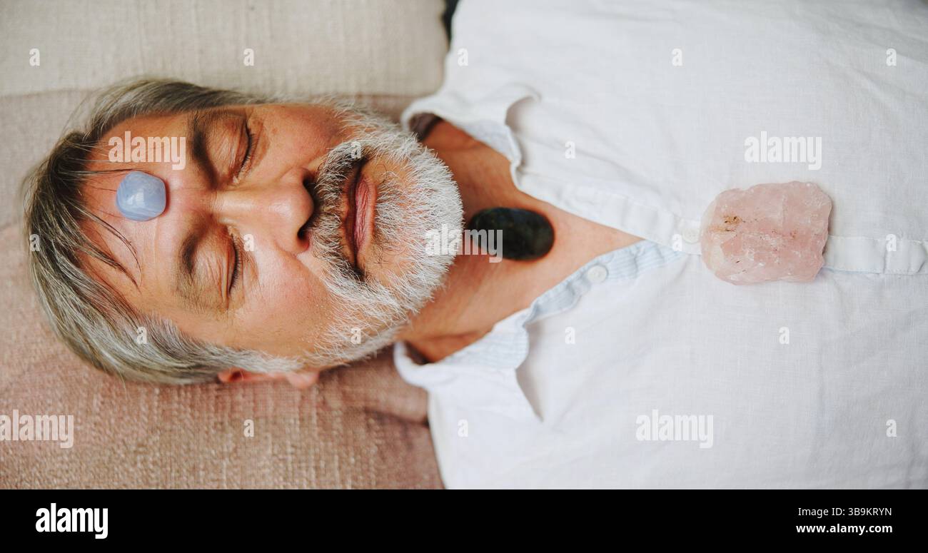 Kristall, Meditation und höher mit asiatischem Mann auf dem Boden für Energiehaushalt, Heilritual oder Spiritualität. Chakra des dritten Auges, Frieden oder ganzheitlich mit Stockfoto