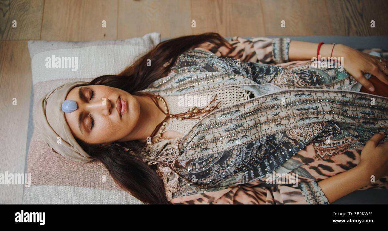 Frau, Kristall und Heilung mit Chakra auf dem Boden, oben und Energie für Therapie mit Erholung im Urlaub. Menschen, Felsen und ganzheitliche Pflege mit Mineralien Stockfoto