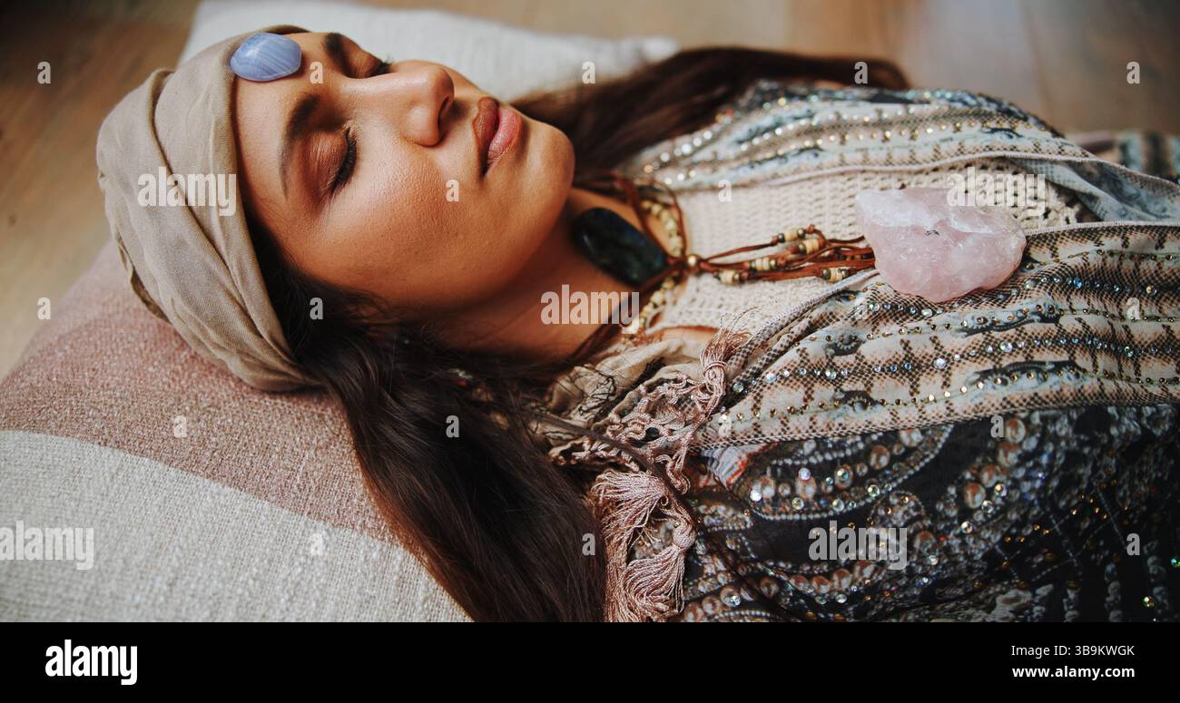 Frau, Kristall und Stirn mit Heilung für Chakra auf dem Boden, Energie oder Ruhe für Therapie im Urlaub. Menschen, Felsen und ganzheitliche Pflege mit Mineralien Stockfoto