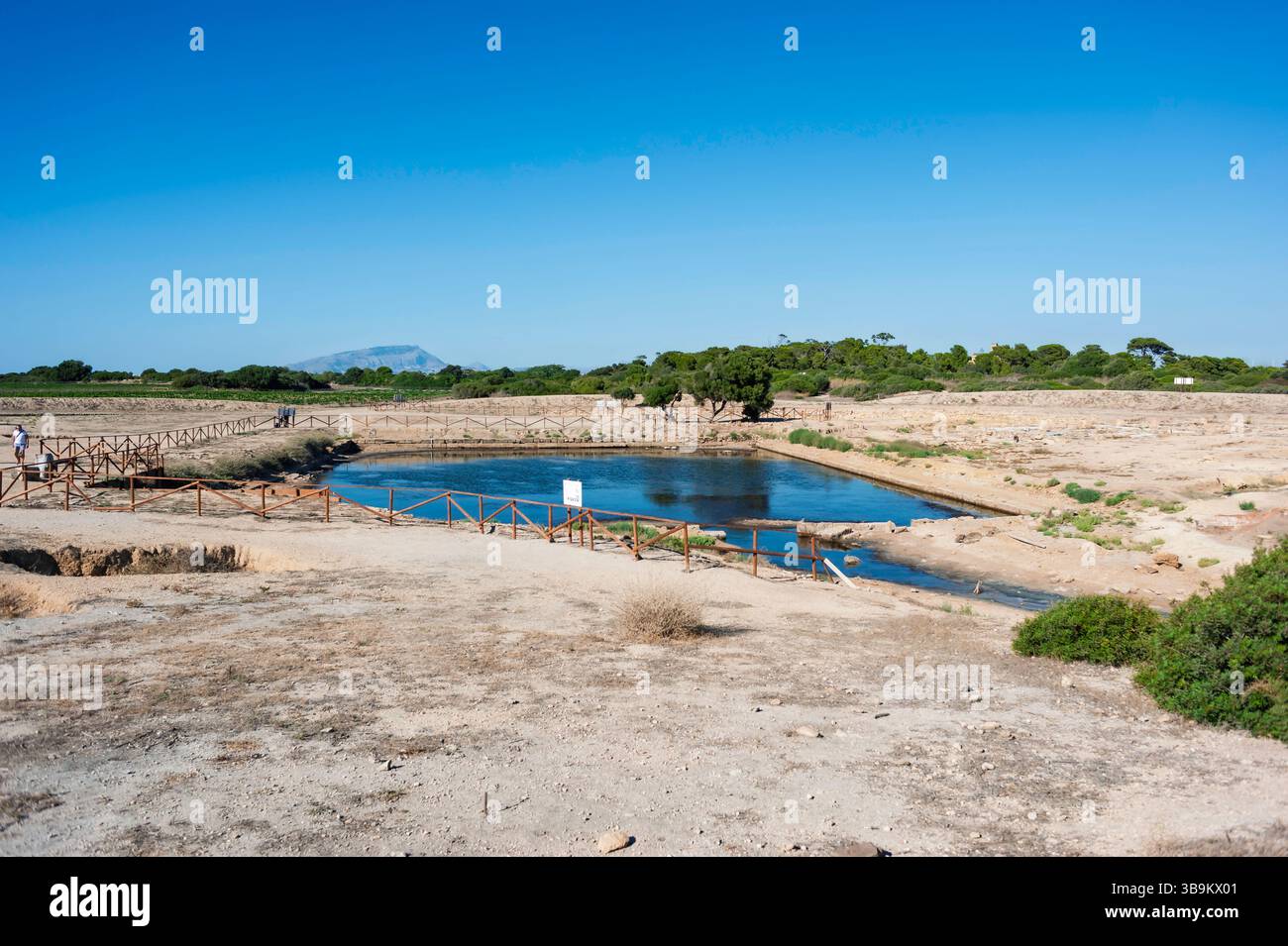Archäologische Stätte auf der Insel Mozia, Sizilien, Italien. Blick auf das Kothon-Becken unter blauem Himmel, umgeben von trockener Landschaft und Geschichte. Stockfoto