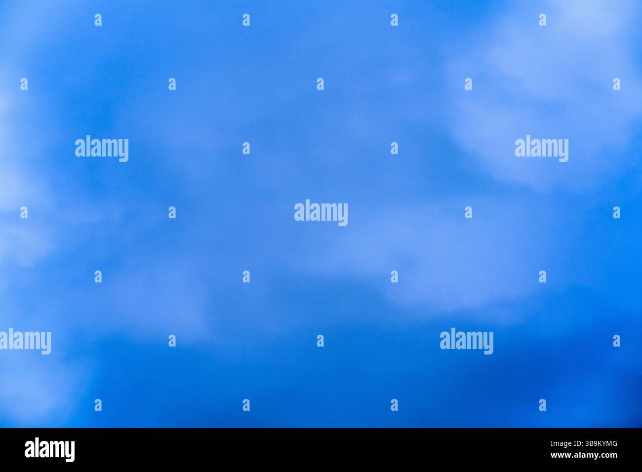Ein klarer blauer Himmel erfüllt die Aussicht mit weißen Wolken, die sich träge unter dem hellen Sonnenlicht treiben. Dieser ruhige Mittagsmoment fängt das essen ein Stockfoto