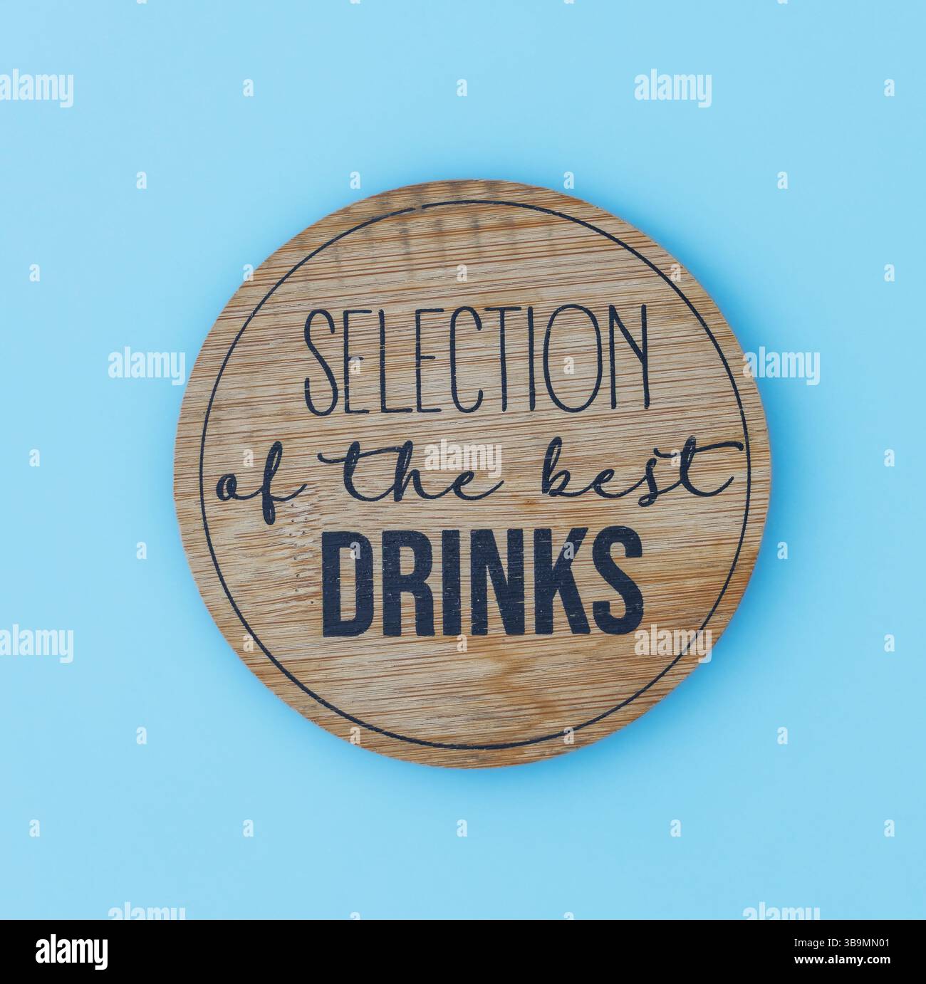 Ein runder Holzuntersetzer mit einem klaren und minimalistischen Design, in dem die Worte „Celection of the Best Drinks“ eingeprägt sind Stockfoto