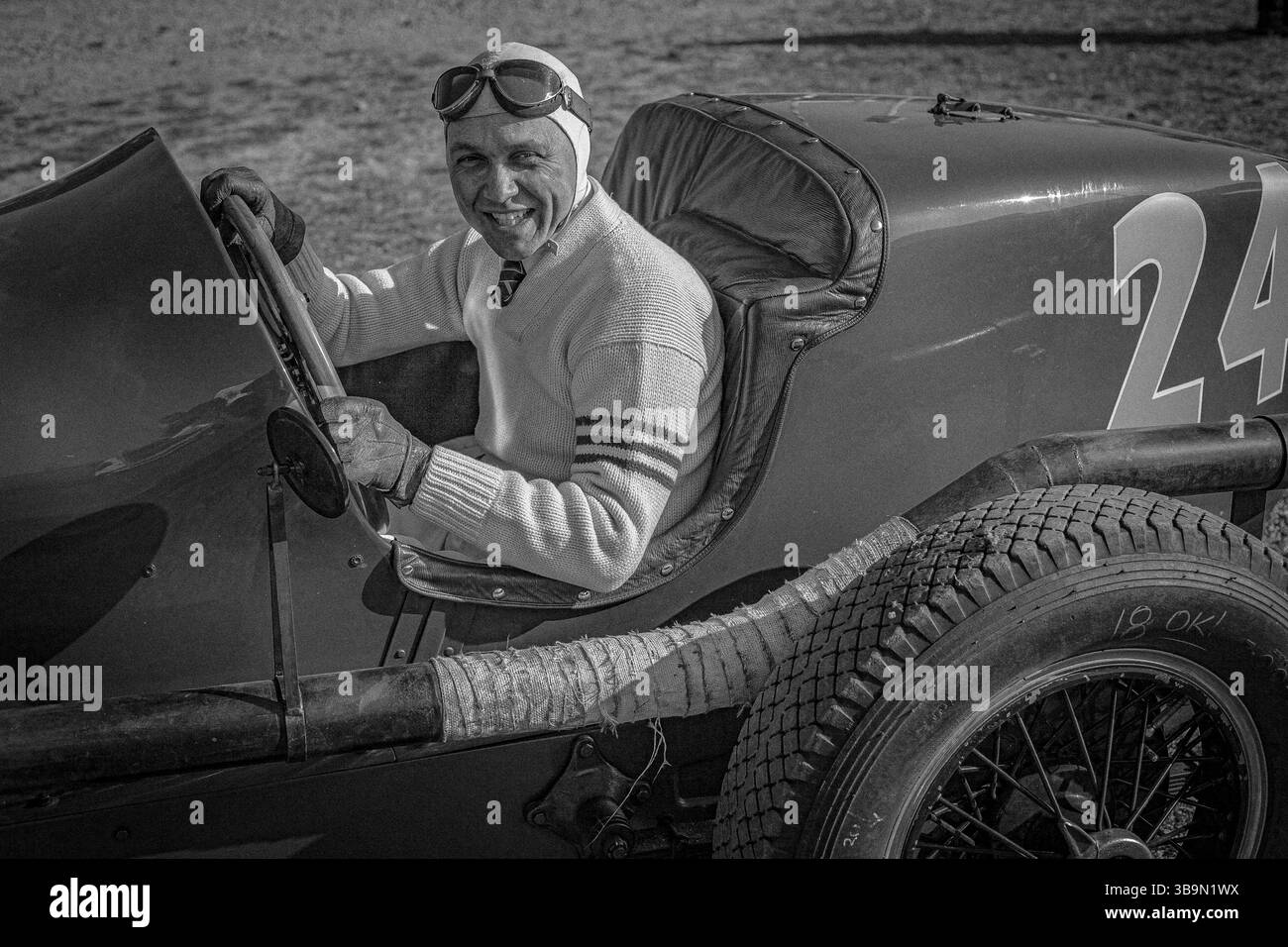 Vintage-Rennfahrer im historischen Helm, der im Graham 8 Lucenti-Rennwagen 1932 bei einem historischen Motorsport-Event sitzt. Stockfoto
