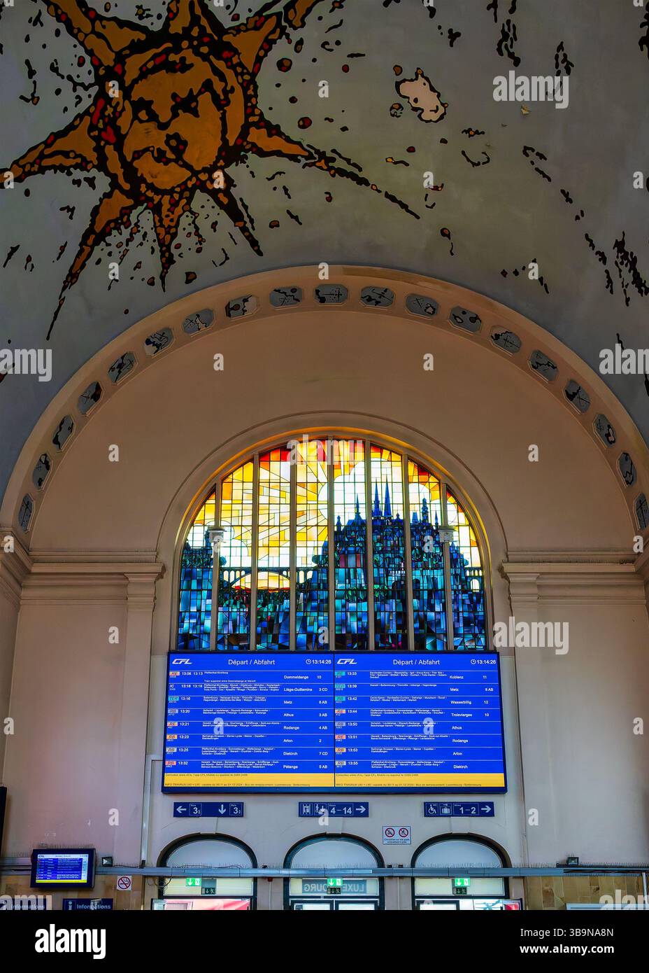 Die Haupthalle des luxemburgischen Hauptbahnhofs verfügt über eine gewölbte Decke, die von Armand Strainchamps bemalt wurde, und ein Buntglasfenster, das die Stadt SK darstellt Stockfoto