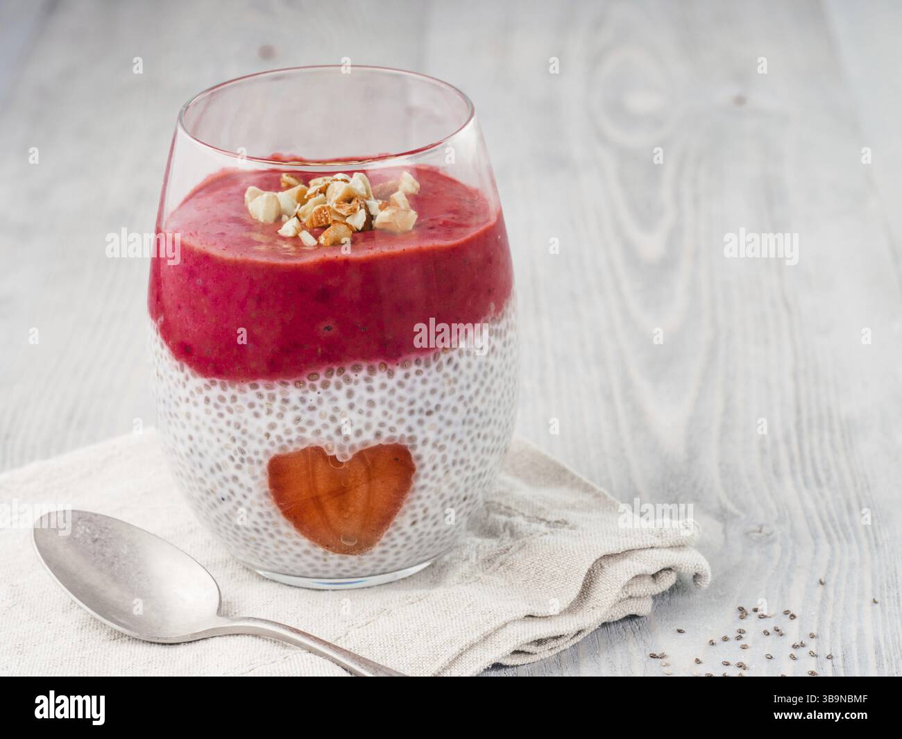 Idee für gesundes Frühstück am Valentinstag: Chia Pudding mit roten Beeren Püree, gehackte Mandeln auf und Erdbeere in der Form des Herzens. Kopieren Sie sp Stockfoto