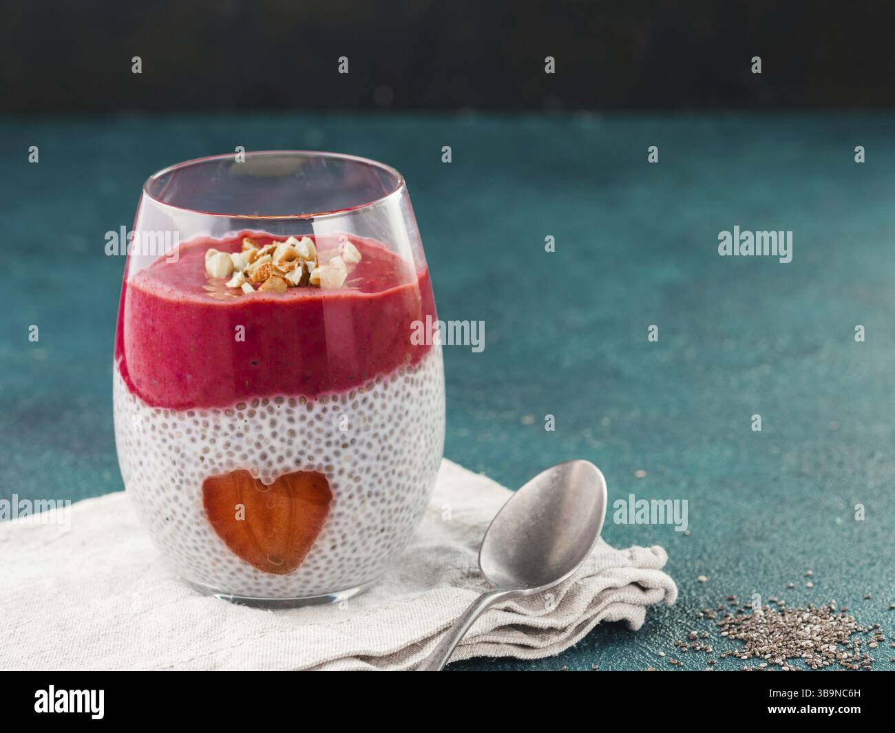 Idee für gesundes Frühstück am Valentinstag: Chia Pudding mit roten Beeren Püree, gehackte Mandeln auf und Erdbeere in der Form des Herzens. Kopieren Sie sp Stockfoto