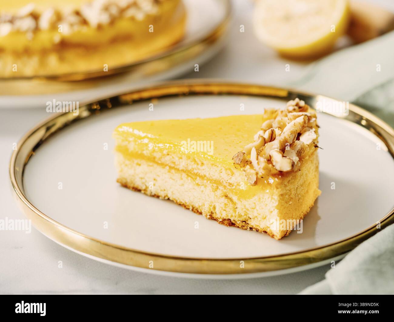 Ein Stück köstlicher Zitronentorte oder Zitronenkuchen, modern dekoriert mit Walnüssen auf ästhetischem Teller. Ästhetik des traditionellen klassischen französischen Zitronenkuchens Stockfoto