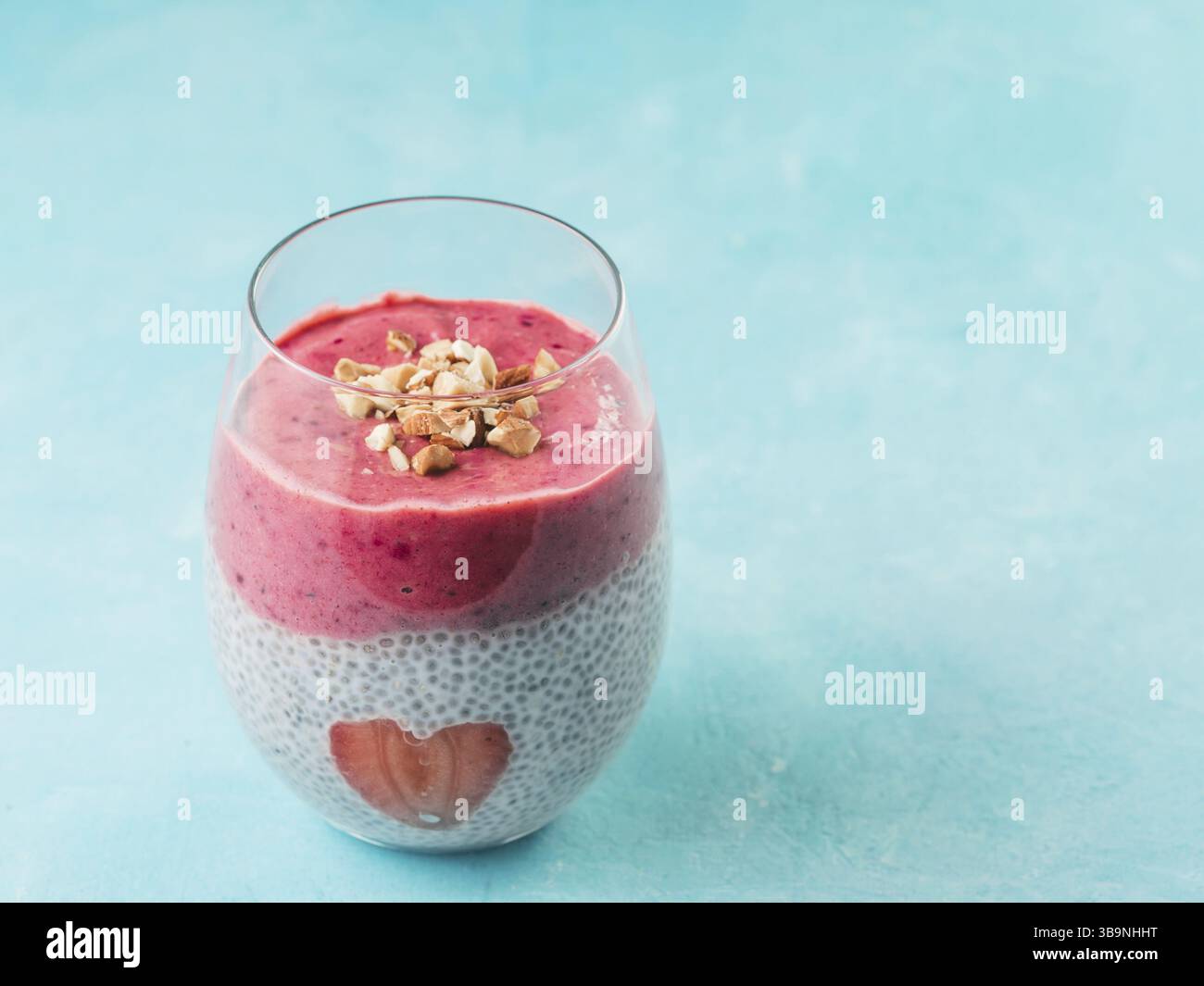 Idee für gesundes Frühstück am Valentinstag: Chia Pudding mit roten Beeren Püree, gehackte Mandeln auf und Erdbeere in der Form des Herzens. Kopieren Sie sp Stockfoto