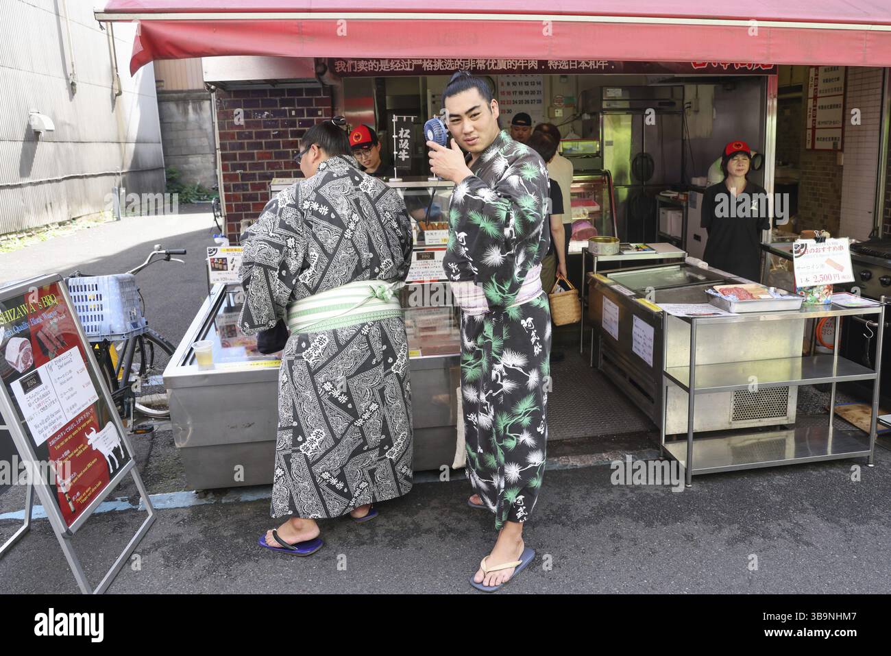 Zwei Sumo-Wrestler an einem Street-Food-Stand auf dem Tsukiji Outer Market in Tokio, Chuo City, Japan, Asien Stockfoto