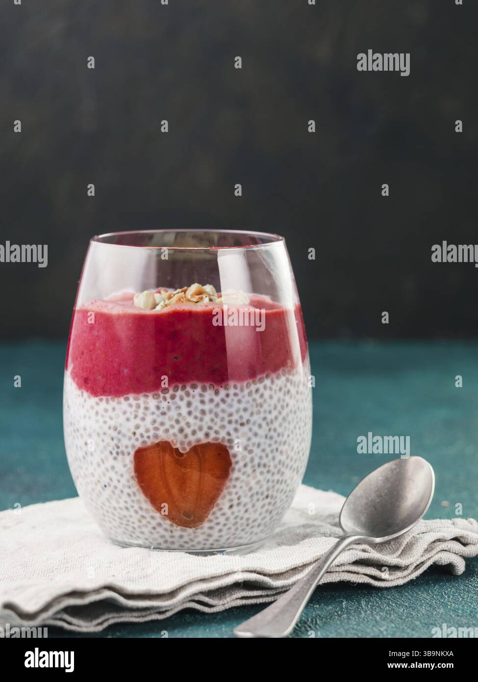 Idee für gesundes Frühstück am Valentinstag: Chia Pudding mit roten Beeren Püree, gehackte Mandeln auf und Erdbeere in der Form des Herzens. Kopieren Sie sp Stockfoto