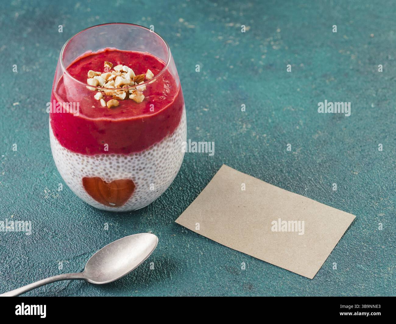 Idee für gesundes Frühstück am Valentinstag: Chia Pudding mit roten Beeren Püree, gehackte Mandeln auf und Erdbeere in der Form des Herzens. Mit bl Stockfoto