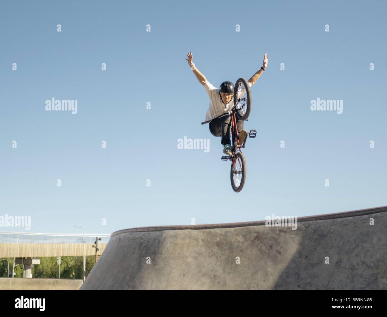 BMX Fahrradfahrer fliegt und Stunt macht keine Hand in der Viertelpfeife. Ein erfahrener BMX-Freestyler springt über die Viertelrampe und macht einen Lufttrick No H Stockfoto BMX Fahrradfahrer fliegt und Stunt macht keine Hand in der Viertelpfeife. Ein erfahrener BMX-Freestyler springt über die Viertelrampe und macht einen Lufttrick No H Stockfoto