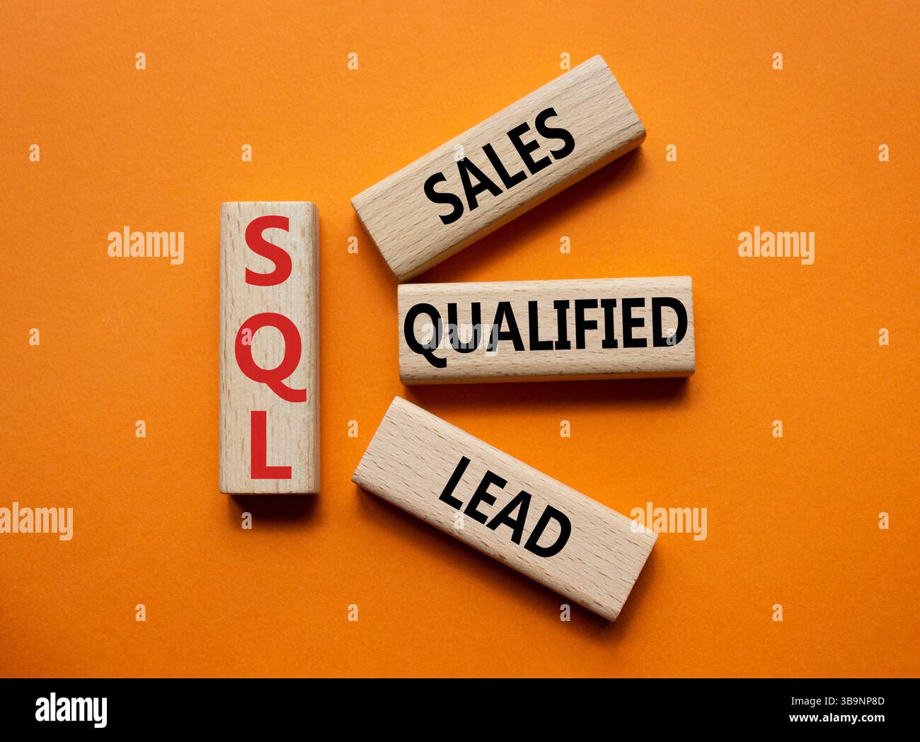 SQL - qualifizierter Lead für Vertrieb. Holzwürfel mit SQL-Wörtern. Wunderschöner orangefarbener Hintergrund. Business- und SQL-Konzept. Kopierbereich. Stockfoto