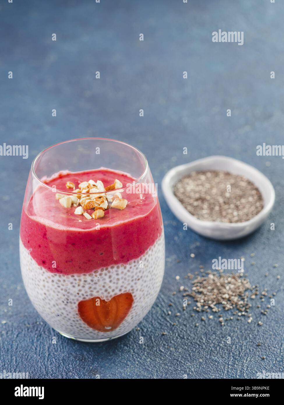 Idee für gesundes Frühstück am Valentinstag: Chia Pudding mit roten Beeren Püree, gehackte Mandeln auf und Erdbeere in der Form des Herzens. Kopieren Sie sp Stockfoto