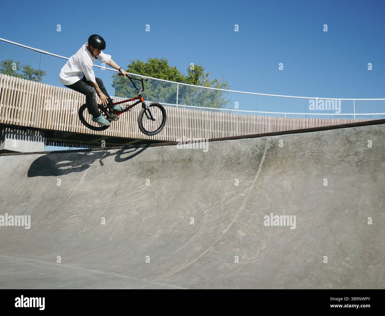 BMX-Fahrer mit Lufttrickrodeln auf Betonviertelrohr im Skatepark. Erfahrener BMX Freestyler springt über den Quarter Pipe Ramp Skatepark. Sie Stockfoto BMX-Fahrer mit Lufttrickrodeln auf Betonviertelrohr im Skatepark. Erfahrener BMX Freestyler springt über den Quarter Pipe Ramp Skatepark. Sie Stockfoto