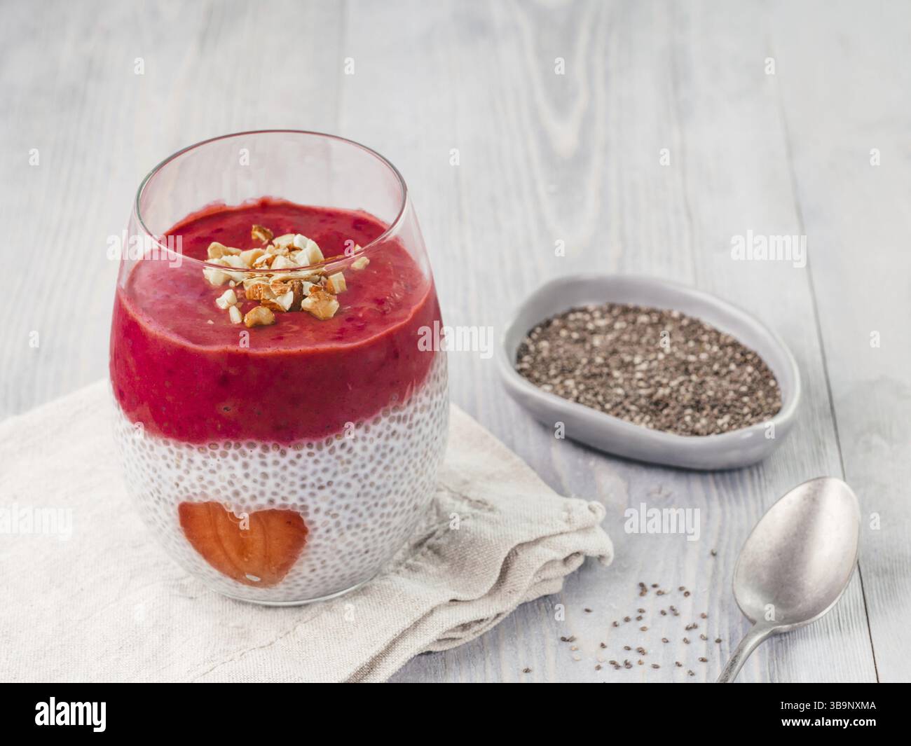 Idee für gesundes Frühstück am Valentinstag: Chia Pudding mit roten Beeren Püree, gehackte Mandeln auf und Erdbeere in der Form des Herzens. Kopieren Sie sp Stockfoto
