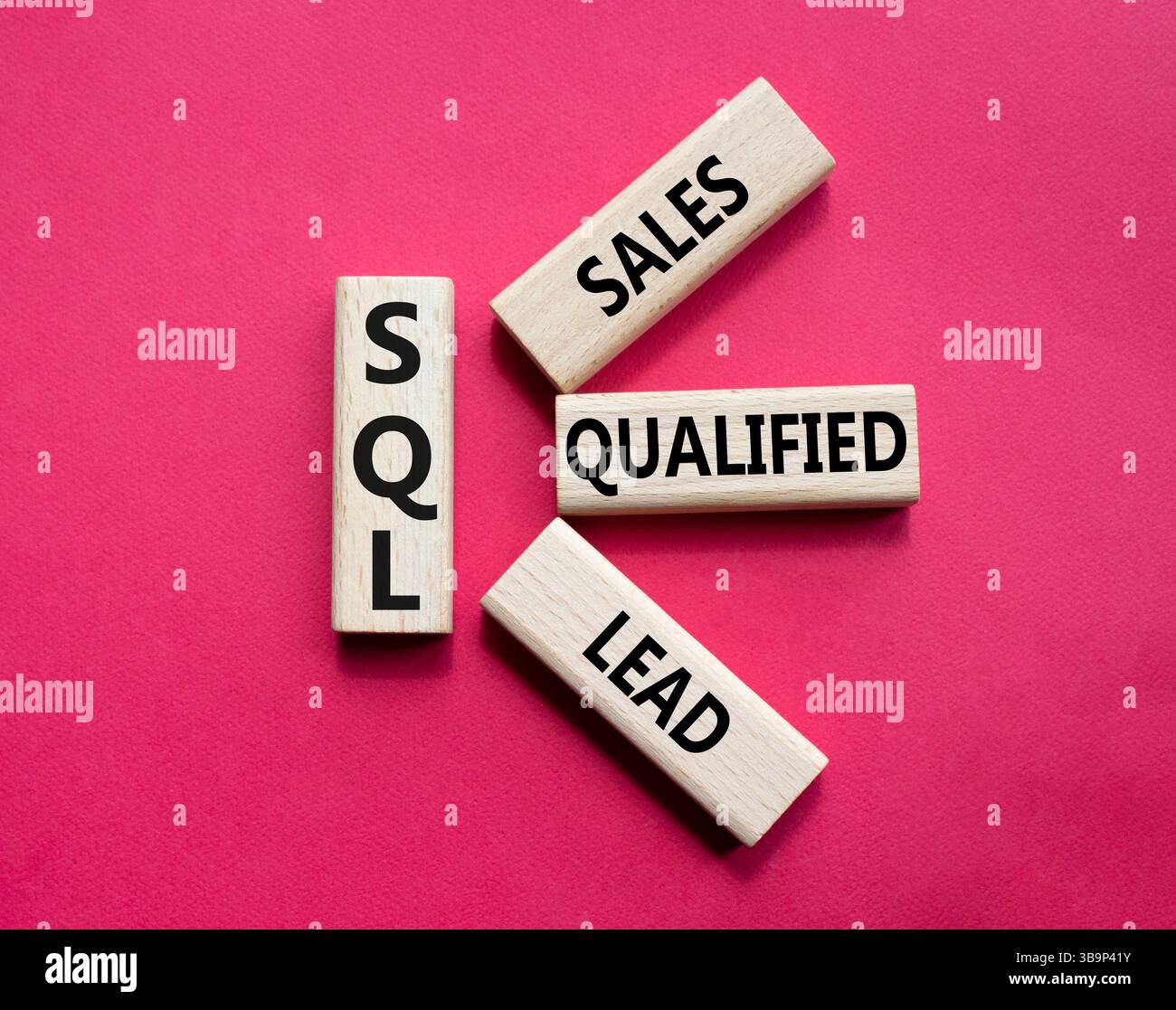 SQL - qualifizierter Lead für Vertrieb. Holzwürfel mit SQL-Wörtern. Schöner roter Hintergrund. Business- und SQL-Konzept. Kopierbereich. Stockfoto