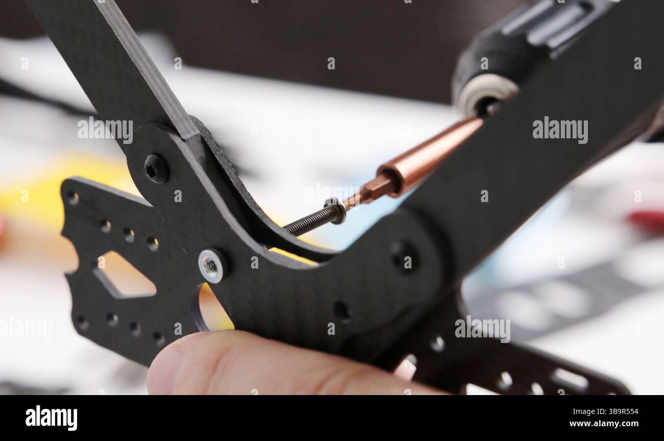 Festziehen der Schrauben in das Kohlegehäuse des fpv-DIY-Copters Stockfoto