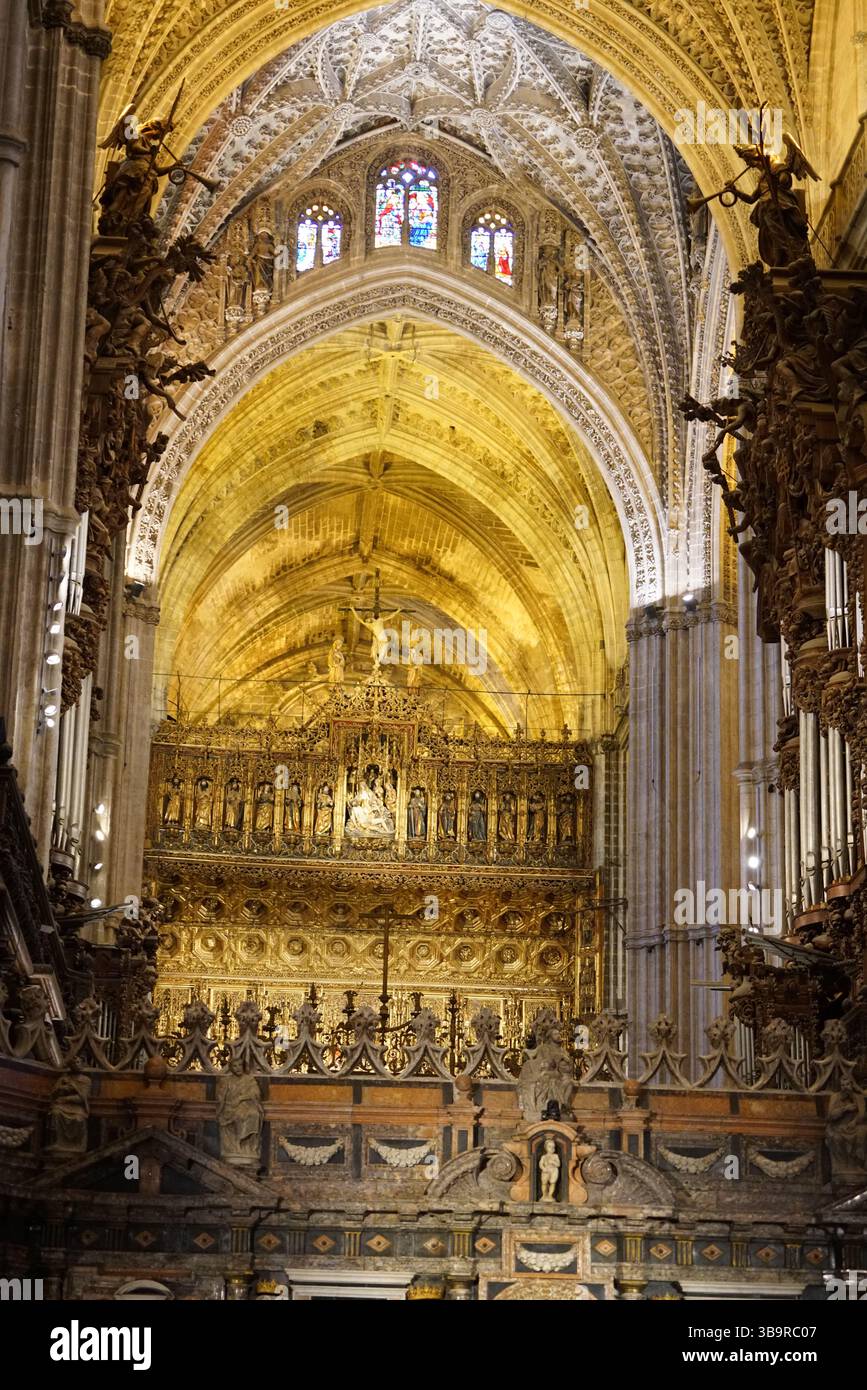 Das Innere der gotischen Kathedrale in Sevilla, Spanien, mit einem reich vergoldeten Chorbereich, Rippengewölben, Steinsäulen und Buntglasfenstern. Sevilla Stockfoto